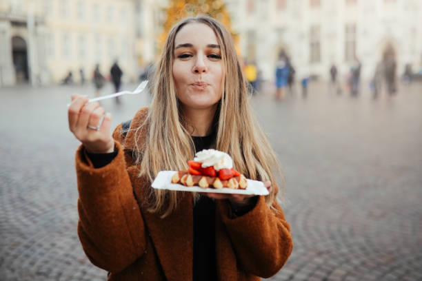 femme mangeant des gaufres de belgique - cookie women eating beautiful photos et images de collection