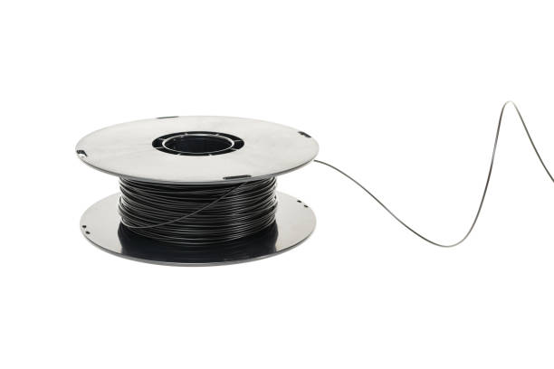 istock 3D Printer Plastic Filament. Spool of black thermoplastic wire for 3D printing close up isolated on white background 1246346315
