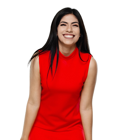Front view of aged 20-29 years old who is beautiful with black hair latin american and hispanic ethnicity young women standing in front of white background wearing dress who is shouting and celebrating