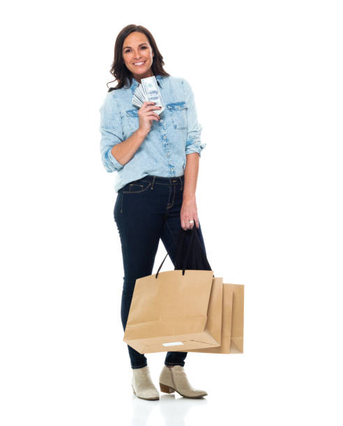 mujer caucásica shopaholic delante de fondo blanco usando jeans y sosteniendo la moneda - laughing women us paper currency isolated fotografías e imágenes de stock