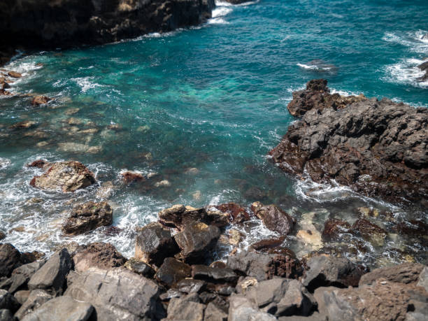 istock Beautiful image of ocean waves rolling and breaking on sharp cliffs and rocks in lagoon 1246370105