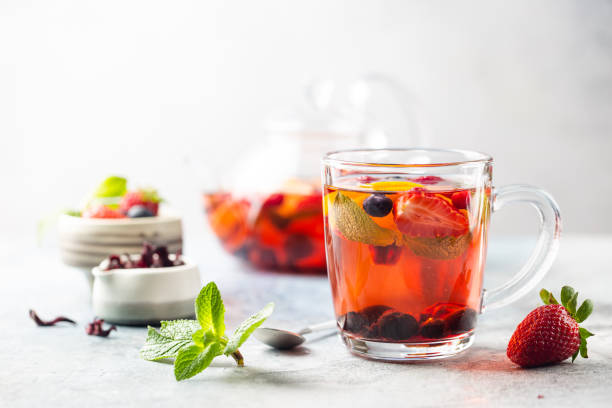 Fruit red tea with berries Fruit red tea with berries in glass cup on white background cafe transparent glass table stock pictures, royalty-free photos & images