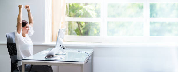 istock Happy Woman At Computer With Hands Raised 1246372555