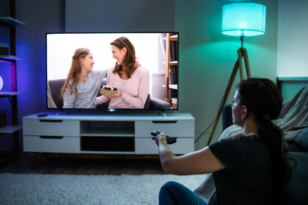 istock Woman Watching TV On Couch Or Sofa 1246374794
