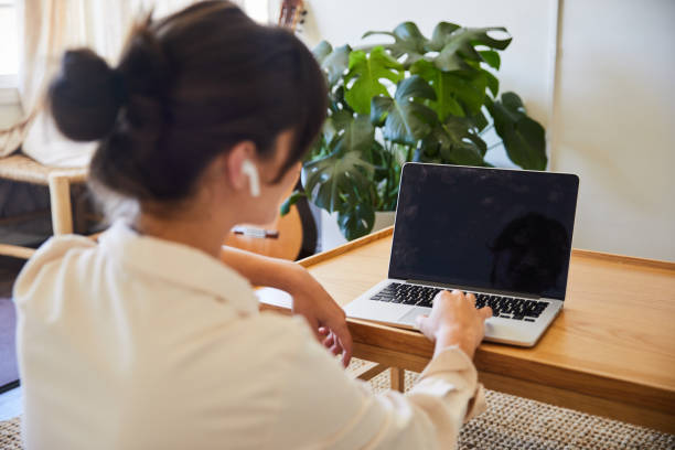 молодая женщина видео чате онлайн с ноутбуком у себя дома - series isolated indoors contemporary стоковые фото и изображения