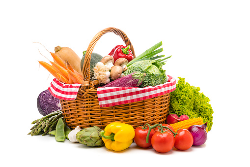 Healthy food: fresh organic vegetables in a wicker basket isolated on white background. Vegetables included in the composition are kale, tomatoes, squash, asparagus, onion, lettuce, carrots, corn, garlic, artichoke, bell pepper, edible mushrooms, radish, among others. High resolution 48,2Mp studio digital capture taken with Sony A7rII and Sony FE 90mm f2.8 macro G OSS lens