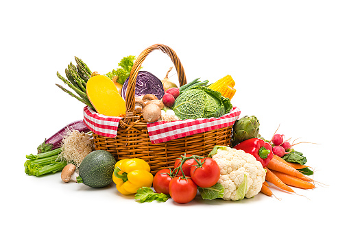 Healthy food: fresh organic vegetables in a wicker basket isolated on white background. Vegetables included in the composition are kale, tomatoes, squash, asparagus, celery, broccoli, eggplant, onion, lettuce, carrots, corn, potatoes, garlic, ginger root, artichoke, bell pepper, edible mushrooms, radish, among others. High resolution 48,2Mp studio digital capture taken with Sony A7rII and Sony FE 90mm f2.8 macro G OSS lens