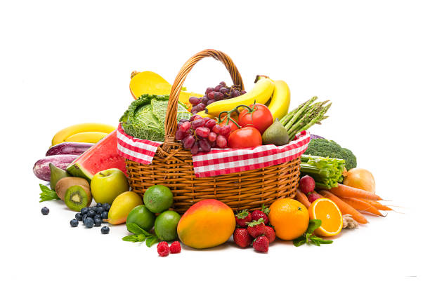 Healthy food: fresh organic fruits and vegetables in a wicker basket isolated on white background. Fruits and vegetables included in the composition are banana, grape, fig, oranges, strawberries, mango, lime, pear, apple, blue berries, kiwi, watermelon, kale, tomatoes, squash, asparagus, celery, broccoli, eggplant, onion, carrots, among others. High resolution 48,2Mp studio digital capture taken with Sony A7rII and Sony FE 90mm f2.8 macro G OSS lens