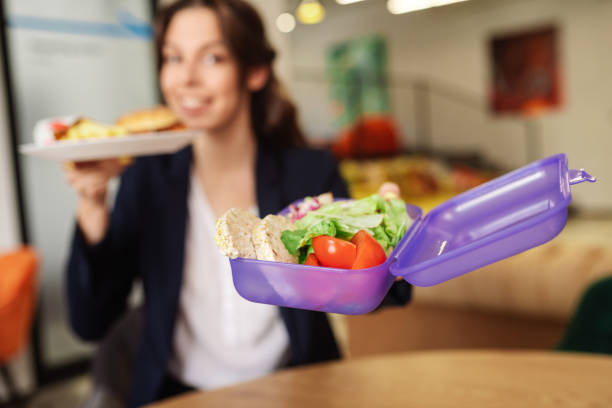 istock Girl holding open lunchbox with cut vegetables 1246394728