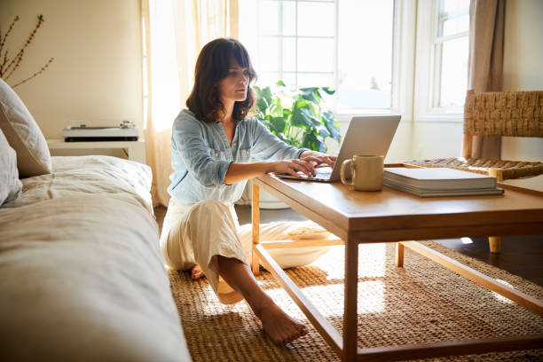 istock Young woman working on a laptop at her coffee table 1246394738