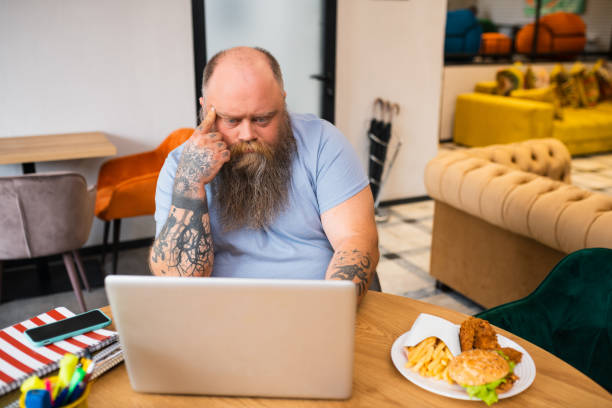 istock Bald tattooed man sitting at the table and thinking 1246395950