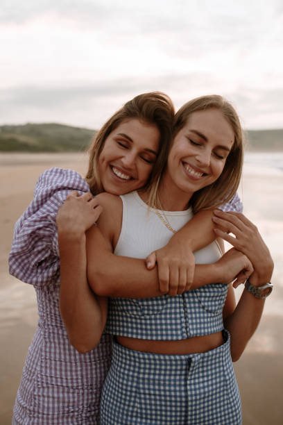 istock Two young women embracing each other at the beach 1246403525