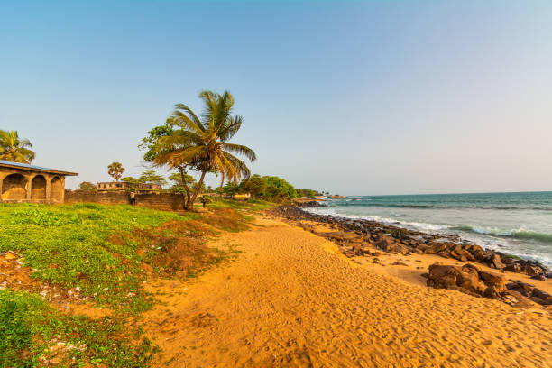 monróvia, libéria - 23 de abril de 2019: praia com areia vermelha e rochas pretas com céu azul na cidade do congo, monróvia, libéria - liberia - fotografias e filmes do acervo