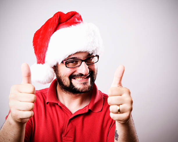 istock Happy man with thumbs up in santa hat 124642343