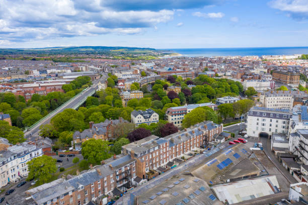 Aerial photo of the town centre of Scarborough in East Yorkshire in the UK taken from the town centre showing guest houses and hotels in the village on a bright sunny summer day playa aérea, ciudad aérea, fotografía aérea, fotos aéreas, playa, frente a la playa, hermosa, costa británica, costa británica, costa británica, pueblo británico, edificio, edificios, centro, ciudad, costa, pueblo costero, costa, vista de drones,
