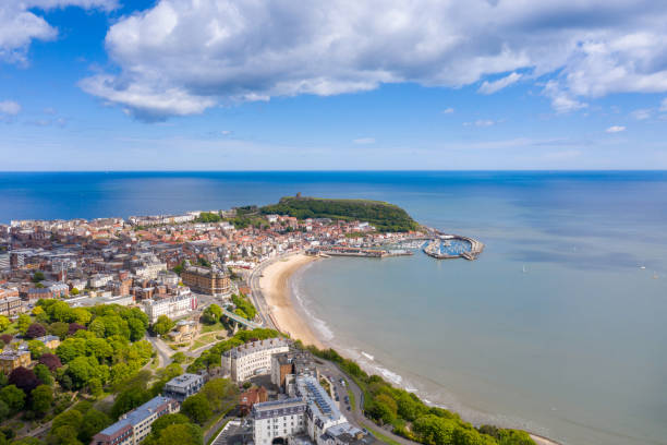Aerial photo of the town centre of Scarborough in East Yorkshire in the UK showing the coastal beach and harbour with boats and the Scarborough Castle on a bright sunny summers day Aerial photo of the town centre of Scarborough in East Yorkshire in the UK showing the coastal beach and harbour with boats and the Scarborough Castle on a bright sunny summers day north yorkshire photos stock pictures, royalty-free photos & images