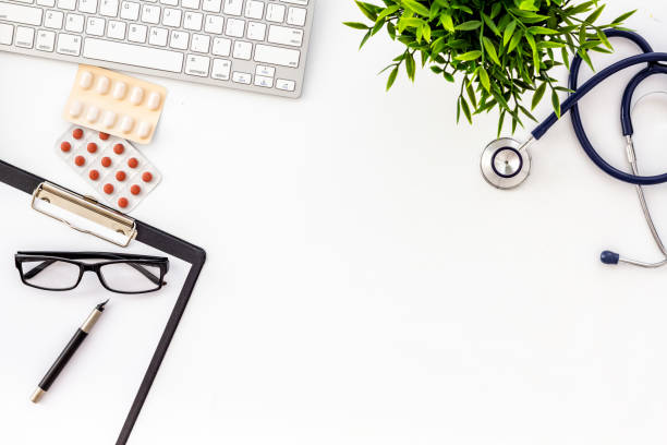 istock Doctor desk with pills, tablet, stethoscope. White table top-down space for text 1246430568