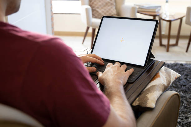 istock Over the shoulders view of a man working from home 1246438599