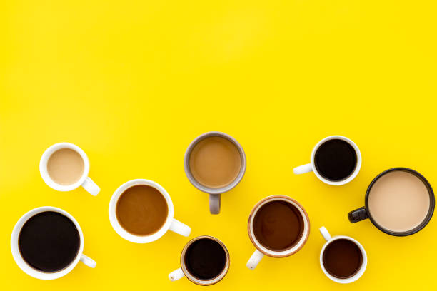 istock Cups of hot drinks on yellow table top-down space for text 1246445492