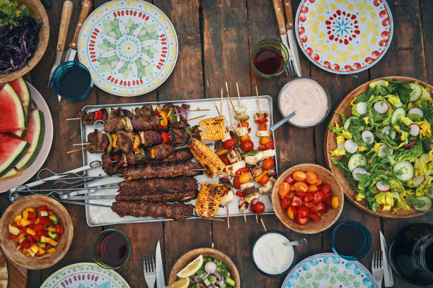 istock Preparing Lamb, Beef and Vegetable Kebab with Green Salad Outside 1246481938