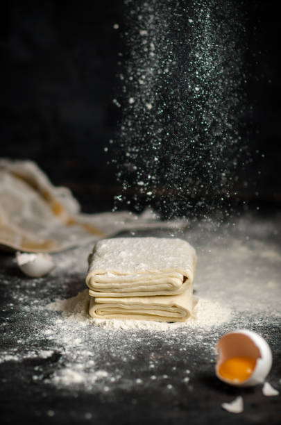 Photo of Homemade raw puff pastry on black background