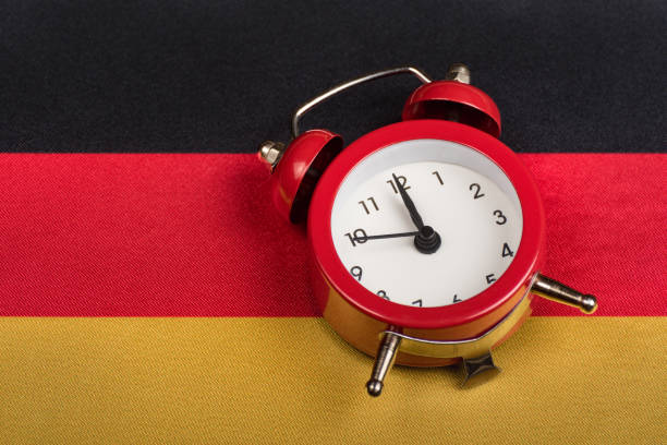 istock Germany flag and vintage alarm clock close up. Time to learn German 1246505053