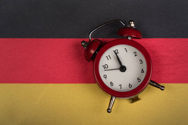 istock Germany flag and vintage alarm clock close up. Time to learn German 1246505057