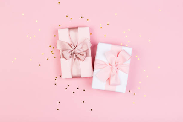 istock Gift or gift box and stars confetti on a pink table from above. Flat composition for birthday, mothers day or wedding. 1246506682