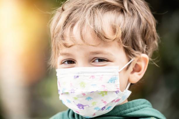 istock Little child boy looking at the camera using a protective mask 1246518465