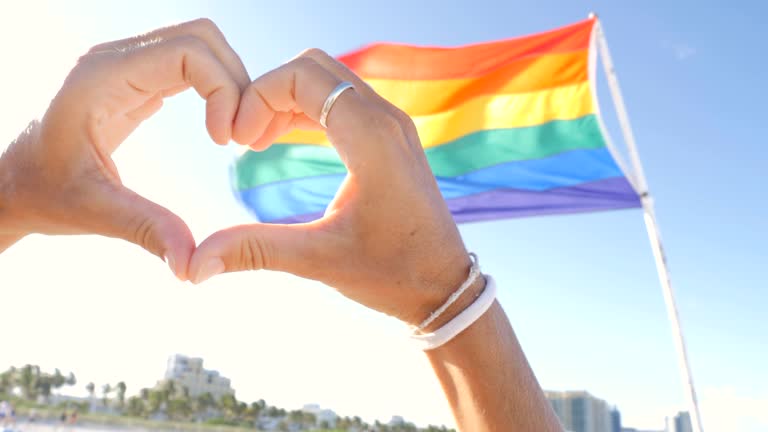 Hands making heart with hands on gay rainbow flag, Miami Beach, Lgbt concept, Miami Beach -slow motion