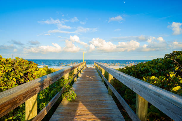 Cocoa Beach Florida Boardwalk on beautiful Cocoa Beach, Florida with blue sky and clouds. cocoa beach stock pictures, royalty-free photos & images