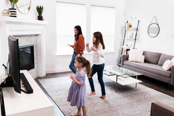istock Mom and daughters exercise to workout video together 1246536639