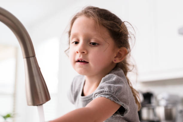 istock Adorable little girl washes her hands 1246537761