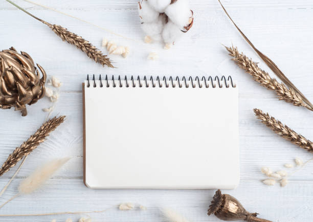 istock Empty notebook with golden dry flowers 1246547374
