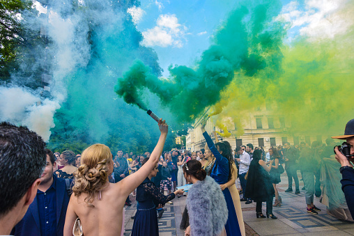 Sofia, Bulgaria - May 25 2019: Graduates gathering in front of National Theater to celebrate their graduation with colored smoke sticks.
