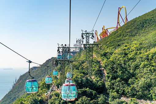 The sunny view of cable car and theme park near to ocean