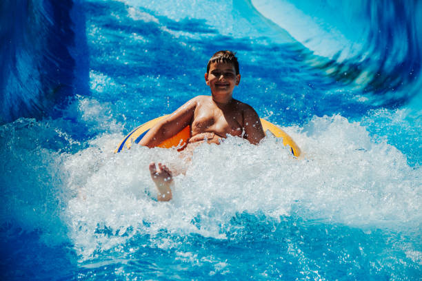 istock Happy boy having fun in water park 1246548326