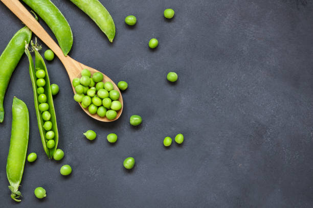 fresh green peas with pod in bowl and spoon on rustic table, healthy green vegetable or legume ( pisum sativum ) - green pea pea pod vegetable freshness imagens e fotografias de stock