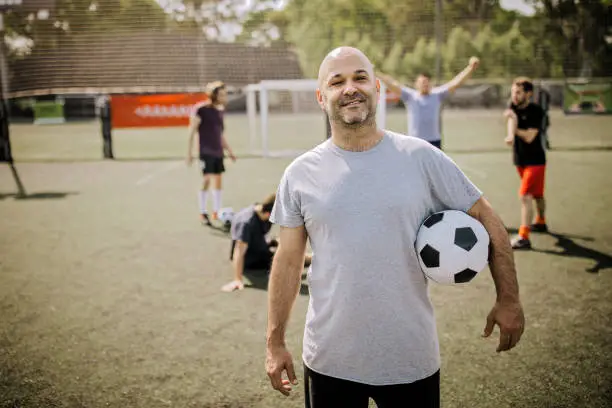 Portrait of men on soccer field outdoors, after training with friends