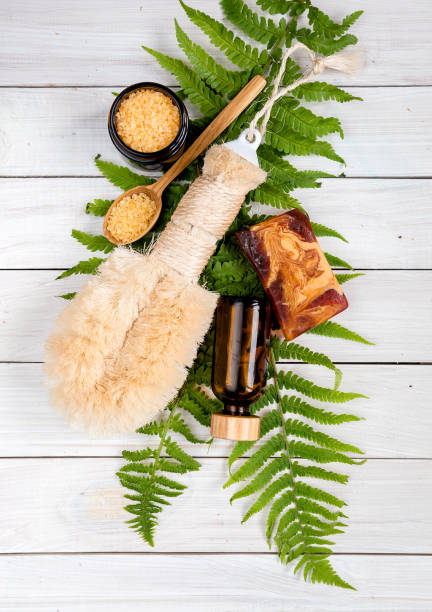 istock spa theme objects on white wooden background Spa setting with pot of moisturizing cream,scrub ,bamboo brush and bath salt with leaf on white background 1246561901