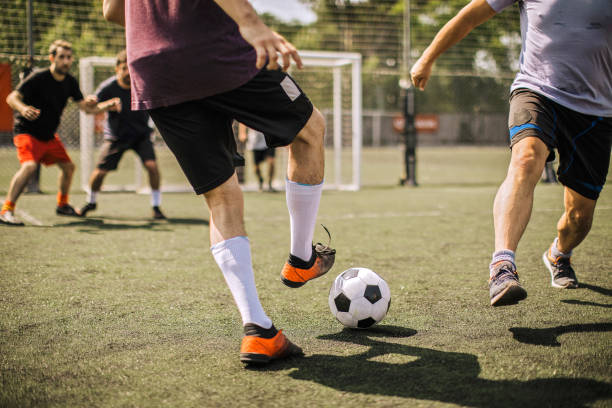 calciatore maschio che calcia pallone da calcio - tirare in rete foto e immagini stock