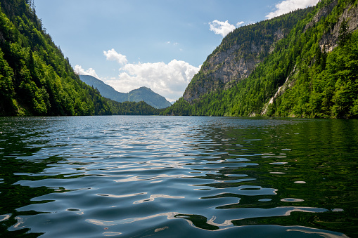 Toplitzsee, Austria - July 16th 2019: Stunning view of the totally by mountains embedded Lake Toplitz. On the right, one of the two waterfalls is visible (Traunursprung).