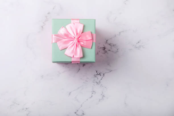 istock Pink box with ribbon and bow on a marble background.top view.space for text 1246574166