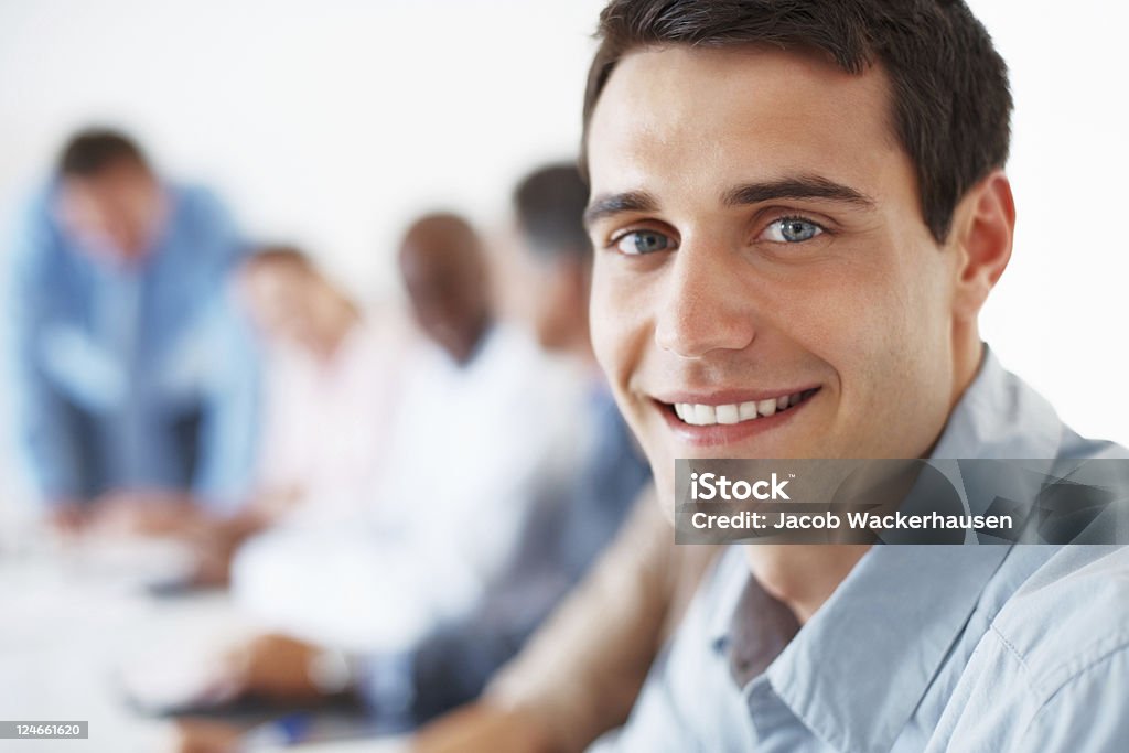 Happy young executive Closeup portrait of happy male executive smiling during meeting with colleagues 20-29 Years Stock Photo