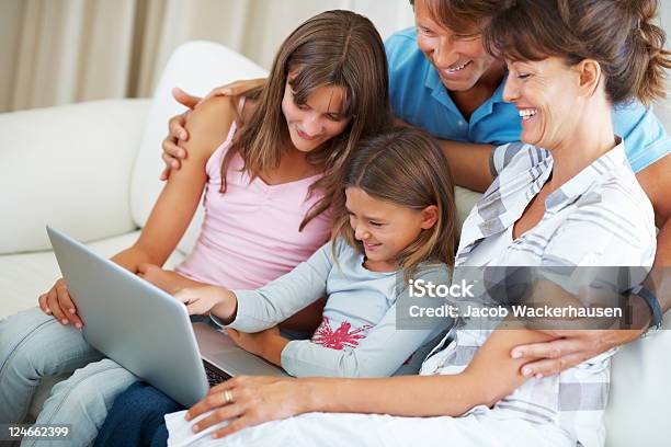 Foto de Família De Quatro Usando O Laptop E Sorrindo e mais fotos de stock de 40-49 anos - 40-49 anos, Adolescente, Adulto