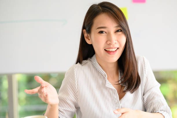 istock Smiling Asian woman explaining something to cemera 1246654236