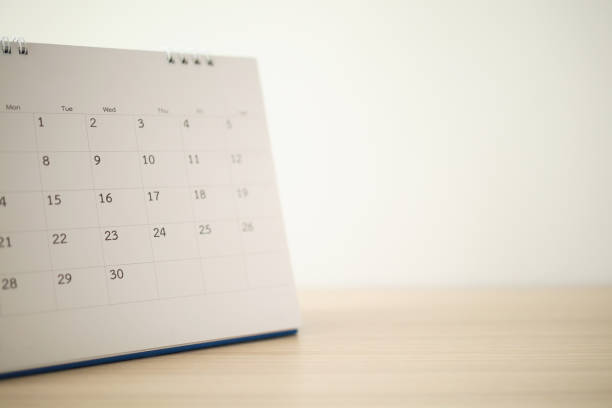 istock Calendar page close up on wood table with white wall background 1246689266