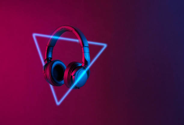 istock Modern black wireless headphones lith with neon light on abstract black background with copy space 1246689573