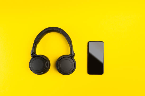 istock Creative audio mobile application concept with smartphone and wireless headphones on colorful background with copy space 1246689740