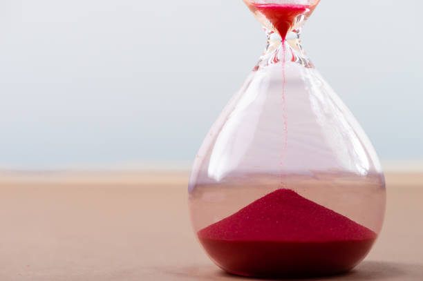 istock Hourglass with flowing sand on table. Time management 1246692310